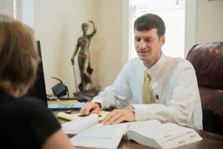 Travis Studdard meets with a client about her workers' compensation case