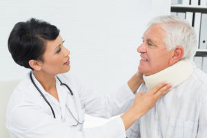 Female doctor examines elderly patients neck with collar