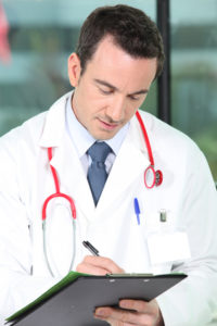 Male doctor writing a prescription or an order for a test or a referral
