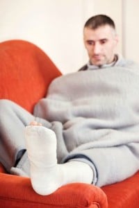Many with leg injury rests leg on sofa arm