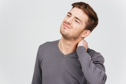 Young man suffering from flank pain on grey background Stock Photo