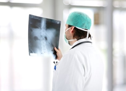 A doctor checks an x-ray for a spinal cord injury