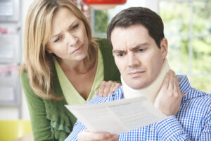 A husband and wife read a letter concerning the scheduling of a functional capacity evaluation for the husband's neck injury