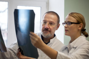 Male and femal doctor examining x ray images