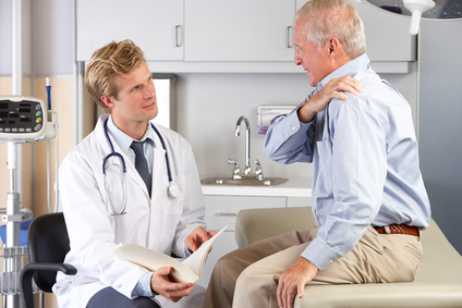 Doctor examining man with shoulder pain