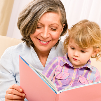Grandmother and granddaughter reading book together