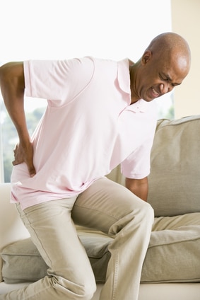 Man getting off couch with back pain